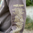 Load image into Gallery viewer, Gray sweatshirt with yellow text listing coastal towns on a blurred natural background